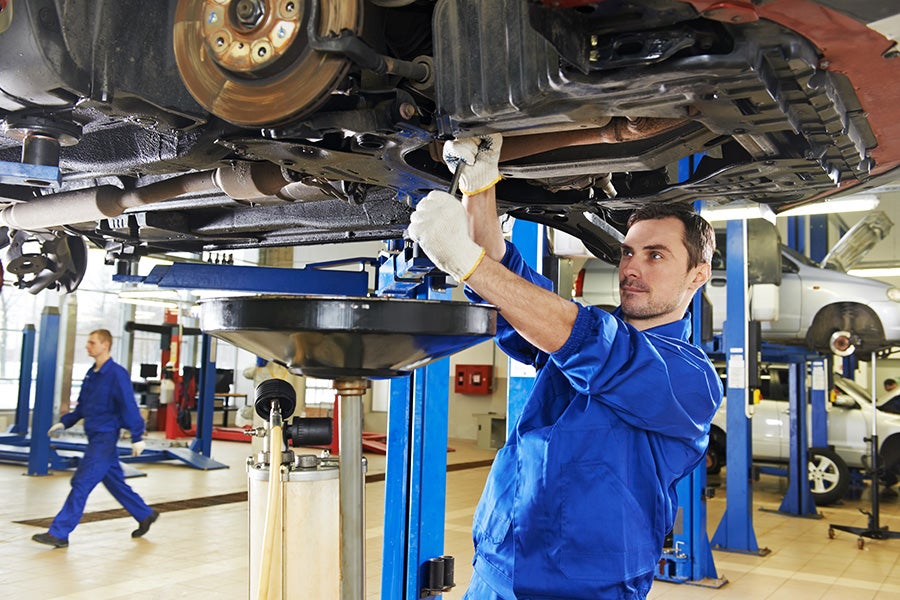 Mechanic inspecting the vehicle in an automotive service center